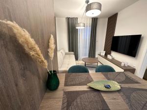 亚霍里纳FORESTA Apartment Jahorina的一间带餐桌的客厅和一间带电视的客厅