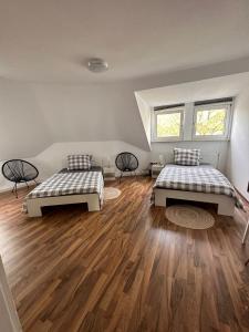 帕德博恩Zimmer im Zentrum - in der Nähe zum Hauptbahnhof的客房内设有两张床,铺有木地板,设有两扇窗户。