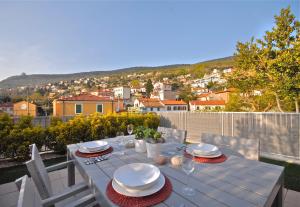 的里雅斯特Casa Vacanze Barcola的阳台上配有带盘子和玻璃杯的白色桌子