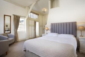 克兰布鲁克克兰布鲁克乔治酒店的卧室配有一张白色大床和一把椅子