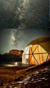 瓦迪拉姆Karam Wadi Rum camp的星空下田野上的帐篷