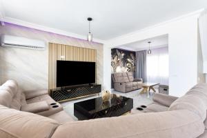 阿德耶Villa Exotica的客厅配有两张沙发和一台电视