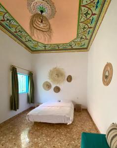 塔哈佐特Kasbari House的一间卧室配有一张带彩绘天花板的床
