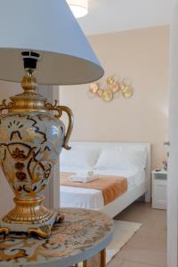 加利波利L'Affaccio Rooms - Lungomare Gallipoli的睡床旁边的桌子上的一个花瓶
