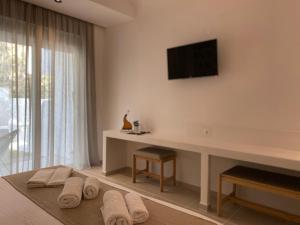 法里拉基Ladiko Inn Hotel Faliraki -Anthony Quinn Bay的卧室配有壁挂式电视和毛巾。