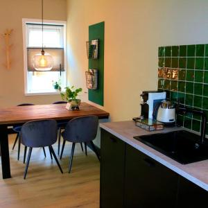 德文格洛De Juffer van Batinghe的厨房配有桌椅和水槽。