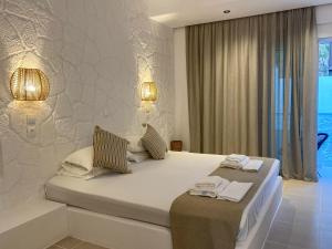 法里拉基Ladiko Inn Hotel Faliraki -Anthony Quinn Bay的一间白色卧室,配有两张床和窗户