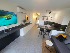 杜柏À Durbuy的客厅和带大屏幕平板电视的厨房
