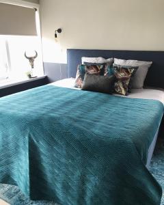 德文格洛De Juffer van Batinghe的一间卧室配有一张带蓝色棉被的大床