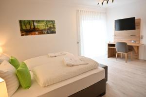 多贝尔Hotel Talblick的一间卧室配有一张床、一张书桌和一台电视