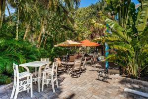 克利尔沃特Blue Water Beachside Villa 6的一个带桌椅和遮阳伞的户外庭院。