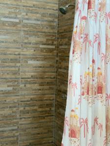 洛维托斯Tayta Surf House的浴室设有淋浴帘和木墙
