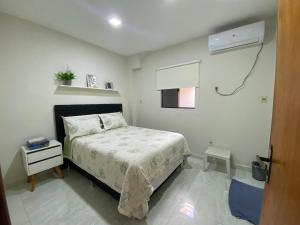 埃斯特城Agradable dormitorio en suite con estacionamiento privado的一间小卧室,配有一张床和空调