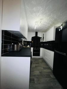 珀弗利特Ensuite Luxury Bedroom In Purfleet的厨房配有黑白柜台和电器