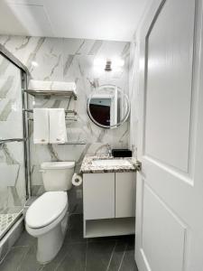法拉盛Starlight Hotel的白色的浴室设有卫生间和镜子