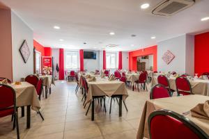 拉默齐亚泰尔默Hotel Ristorante La Mimosa的一间带桌椅和红色墙壁的餐厅