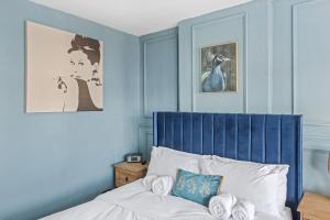 拉夫堡Lovely 2 Bedroom House with Parking的一间拥有蓝色墙壁的卧室和一张带蓝色床头板的床