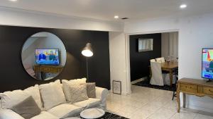 墨尔本Luxury Fitzroy House的客厅配有白色沙发和镜子