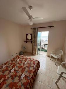 蒙加瓜Apartamento pé na areia de frente para o mar的一间卧室设有一张床和一个美景窗户。