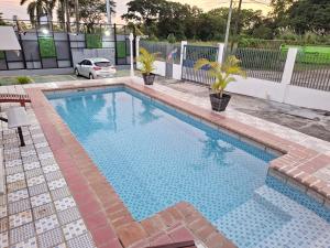 Tocumen巴拿马托库门国际机场快捷酒店的一个带有车的院子内的游泳池