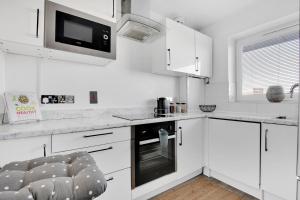 伦敦Peckham apartments by APS的白色的厨房配有白色的橱柜和微波炉