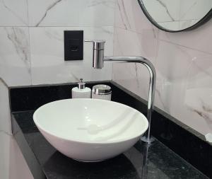 阿奎拉兹B&B Pousada Swiss Residence的带淋浴的浴室内的白色水槽