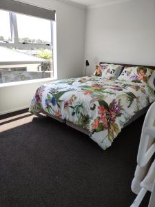 图朗伊Modern House near Motuoapa Tongariro Crossing fishing skiing的一间卧室配有一张带花卉床罩的床