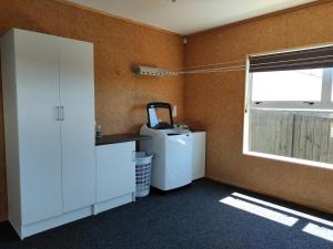 图朗伊Modern House near Motuoapa Tongariro Crossing fishing skiing的客房设有冰箱和窗户。