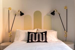 蒙特利尔Maison Place Royale的一张带两个灯和枕头的床