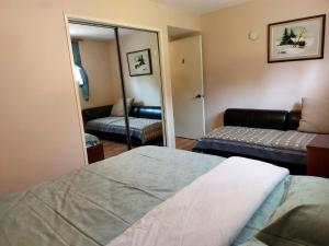 卡尔加里Green Village B&B的一间卧室配有一张床、镜子和一张沙发