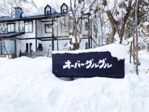 白马村Garden Pension Obergurgl的房屋前雪中的标志