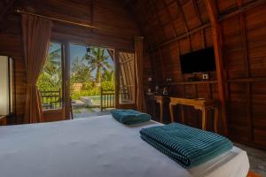 吉安雅Kubu Selat Villa and Glamping的一间卧室配有一张带两个绿色枕头的床