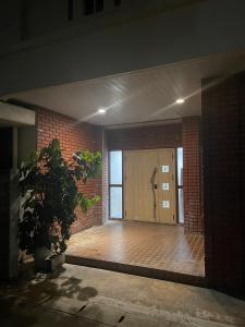 石垣岛Hotel Ishigaki and Chikonkiya的砖砌建筑中一扇门,有盆栽植物
