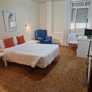 维戈里尔旅馆的一间卧室配有一张床和一张蓝色椅子