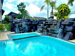 班昌Hideaway Resort Banchang的一个带岩石挡墙的游泳池和一个游泳池