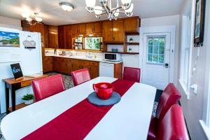 HartfordVintage downtown flat near Holy Hill, Golf &Ski的厨房配有白色的桌子和红色的椅子