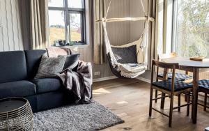 海拉Áskot Cottages的客厅配有蓝色的沙发和吊床