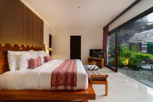 坎古Adepa Resort的一间带大床的卧室和一个阳台