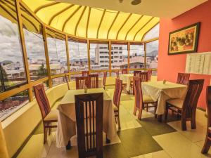 卡哈马卡Gran Kunturwasi Hotel Senior的餐厅设有桌椅和大窗户。