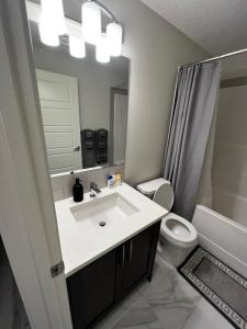 卡尔加里The Waterfront cozy 1 bd suite in Rockland Park, Tuscany NW的一间带水槽、卫生间和镜子的浴室