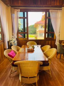 南府Kum-Chan House Hotel (เฮือนก่ำจันทร์)的餐桌、椅子和大窗户