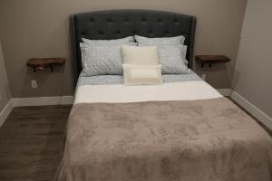 枫树岭Golden Ears Nature's Delight的一间卧室配有一张带黑色床头板和枕头的床。