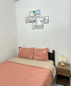 顺化Shine Riverside Homestay的卧室内的一张床铺,墙上挂着照片