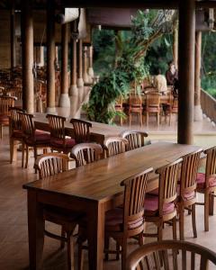 Menanga马哈吉利餐厅度假村的餐馆里一排木桌和椅子