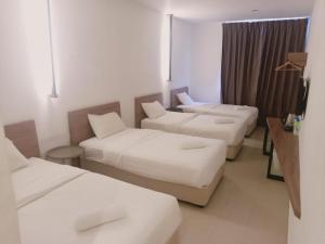 阿罗士打T Hotel Anggerik的酒店客房,设有三张床和一张沙发