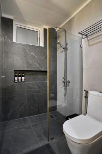 纳苏格布Yugen Suites 208 at Pico De Loro的一间带卫生间和玻璃淋浴间的浴室