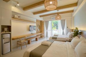 纳苏格布Yugen Suites 208 at Pico De Loro的酒店客房设有两张床和电视。