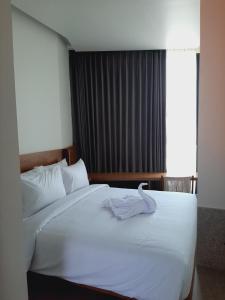塞米亚克The Fields Hotel and Apartment的卧室配有白色的床和毛巾