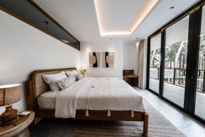 乌布Happiness Apartments Bali Ubud的一间卧室设有一张大床和大窗户