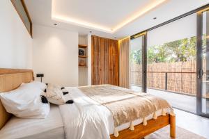 乌布Happiness Apartments Bali Ubud的一间卧室设有一张床和一个大窗户